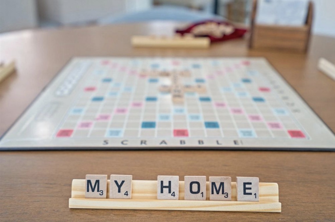 Scrabble tiles spelling 'MY HOME' on a wooden table — Mielgerd Development Corp