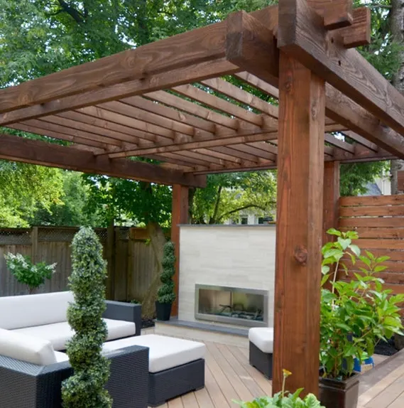 Luxurious outdoor patio with a dark wood pergola, modern fireplace, and comfortable seating.